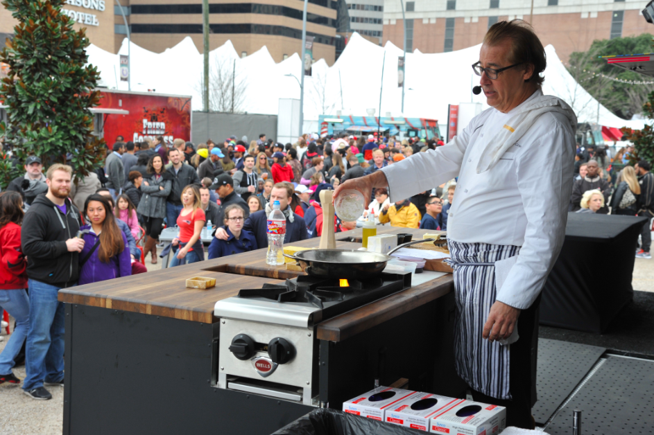 chef cooking in front of large group